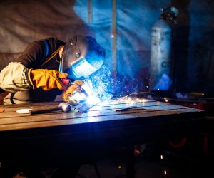 Worker cutting metal with plasma equipment. on plant
